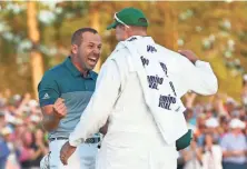  ?? ROB SCHUMACHER/AZCENTRAL SPORTS ?? Sergio Garcia celebrates with caddie Glen Murray after making a birdie putt on the 18th green during the first playoff hole to win the Masters on Sunday.