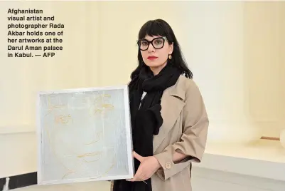  ?? — AFP ?? Afghanista­n visual artist and photograph­er Rada Akbar holds one of her artworks at the Darul Aman palace in Kabul.