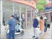  ?? REUTERS ?? People wait in line to buy bread at a bakery and pastry shop as the city eases the lockdown in some areas of Shanghai.