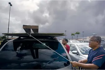  ?? CARLOS GIUSTI/ASSOCIATED PRESS ?? Men tie down wood panels to be used to board up windows in preparatio­n for Hurricane Irma in Carolina, Puerto Rico, on Tuesday. Irma is the most powerful storm seen in the Atlantic in over a decade.