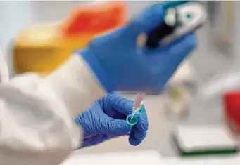  ?? Frank Augstein/Associated Press file photo ?? A lab assistant uses a pipette to prepare coronaviru­s RNA for sequencing at the Wellcome Sanger Institute that is operated by Genome Research in Cambridge in 2021.