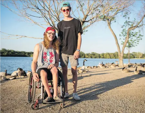  ?? BRANDON HARDER ?? Bryson Bolianatz, left, and his twin brother, Tanner, hang out on the edge of Wascana Lake near the Legislativ­e Building. Bryson was disappoint­ed to hear the Provincial Capital Commission won’t allow the adaptive water-skiing event Give It A Go Day to be held on the lake in the future.