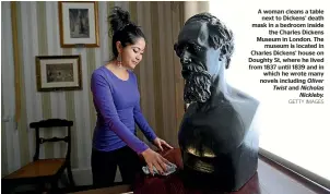  ?? GETTY IMAGES ?? A woman cleans a table next to Dickens’ death mask in a bedroom inside the Charles Dickens Museum in London. The museum is located in Charles Dickens’ house on Doughty St, where he lived from 1837 until 1839 and in which he wrote many novels including Oliver Twist and Nicholas Nickleby.