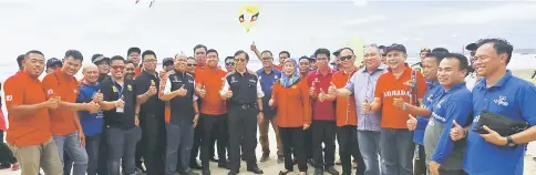  ??  ?? Abang Johari (front, eighth left), flanked by Jamilah and her son Azizul Adenan, with others in a photo-call upon the convoy’s arrival at Pugu beach. — Photos by Muhammad Rais Sanusi