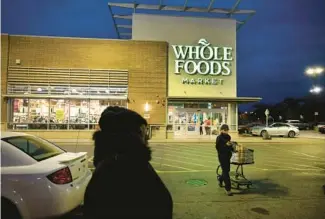  ?? CHRIS SWEDA/CHICAGO TRIBUNE ?? Sekhema Williams, 29, of Oak Lawn, pulls her cart through the parking lot after shopping at the Whole Foods in Chicago’s Englewood neighborho­od on Saturday.