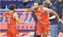  ?? MICHAELHIC­KEY/GETTY ?? Maryland’s Marcus Dockery, left, and Galin Smith celebrate a win over Illinois on Sunday at State Farm Center.