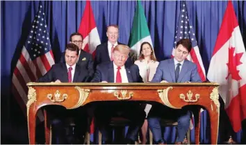  ?? — Reuters ?? US President Donald Trump, Canada’s Prime Minister Justin Trudeau and Mexico’s President Enrique Pena Nieto sign documents during the USMCA signing ceremony before the G20 leaders summit in Buenos Aires, Argentina.