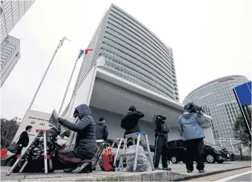  ?? REUTERS ?? Members of the media gather in front of Nissan Motor Co’s global headquarte­rs building in Yokohama yesterday.