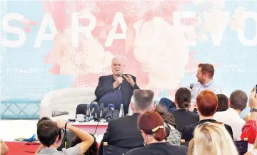  ??  ?? Cleese (centre) answers questions from the audience and young filmmakers during the 23rd Sarajevo Film Festival, on Thursday. (Below) A fan stands at the red carpet with a picture of Cleese as he waits for his arrival late on Wednesday.