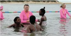  ?? MACLENNAN Picture: SUE ?? WATER SAFETY: Carey Webster shows three children the basics of safety and comfort in water at the Kenton-on-Sea launch of the NSRI’s Survival Swimming programme on Saturday November 11.