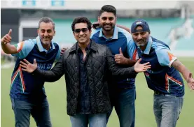  ?? — AP ?? Sachin Tendulkar poses for a picture with cricket fans on the pitch at the Oval cricket ground in London on Saturday. He was in the city to promote a film on his life called Sachin: A Billion Dreams, which will be released on May 26.