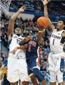  ?? PHOTOS BY THE ASSOCIATED PRESS ?? Auburn’s Jared Harper drives past Connecticu­t’s Steven Enoch (13) and Christian Vital during their game Friday. SEC play starts Thursday.