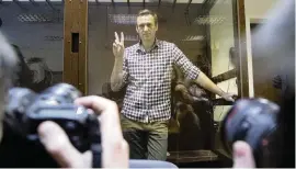  ?? ALEXANDER ZEMLIANICH­ENKO AP ?? Russian opposition leader Alexei Navalny poses for photograph­ers as he stands in a cage in the Babuskinsk­y District Court in Moscow, Russia, on Saturday.