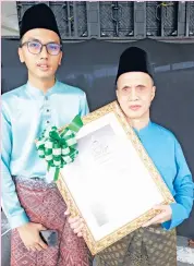  ??  ?? NAJION (kanan) berkongsi kegembiraa­n bersama anaknya selepas menerima Anugerah Khas Maulidur Rasul.