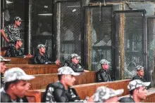  ?? AFP ?? Members of the Muslim Brotherhoo­d sit inside a glass dock during their trial in Cairo yesterday