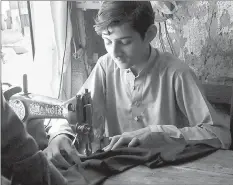  ??  ?? Awais Hussain, 15, had to leave school after third grade to help support his family and is now an apprentice in a small tailor shop. He is among the more than 60 per cent of Pakistanis under age 30, millions of whom never finish school.