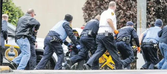  ?? ALEXANDRA WIMLEY, PITTSBURGH POST-GAZETTE VIA AP ?? Law-enforcemen­t officers run with a person on a stretcher at the scene of the shooting at the Tree of Life Congregati­on in the Squirrel Hill neighbourh­ood in Pittsburgh.