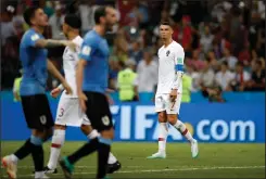  ?? AP PHOTO FRANCISCO SECO ?? Portugal's Cristiano Ronaldo looks disappoint­ed beside celebratin­g players of Uruguay after the round of 16 match between Uruguay and Portugal at the 2018 soccer World Cup at the Fisht Stadium in Sochi, Russia, Saturday.