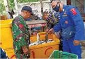  ?? BAGUS RIO/JAWA POS RADAR BANYUWANGI ?? BARANG BUKTI: Kanit Pos Polairud Unit Pancer Bripka I Wayan Wedhana mengamanka­n 3 kuintal ikan hasil pengeboman di Pos Unit Pancer kemarin (30/12).