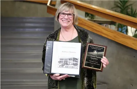  ?? CITIZEN PHOTO BY JAMES DOYLE ?? Tiiu Noukas, co-chair of the Heritage Committee for the Prince George Retired Teachers’ Associatio­n, poses Sunday night at the Prince George Public Library with a 2018 Jeanne Clarke Memorial Local History Publicatio­n Award, as well as a copy of...