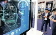  ?? Reuters ?? VISITORS check their phones behind a screen advertisin­g facial recognitio­n software during a conference in Beijing. Algorithm bias has resulted in some facial recognitio­n systems discrimina­ting against certain types of people, says the writer. |