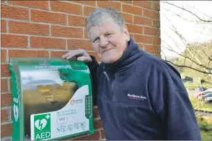  ??  ?? Donnie MacPhee beside the new defibrilla­tor at Glencruitt­en Golf Club.