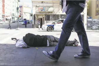  ?? Amy Osborne / Special to The Chronicle ?? A homeless man sleeps on the sidewalk on Ellis and Jones in San Francisco, an area known for its encampment­s of chronicall­y homeless people.