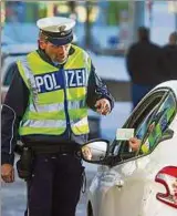  ??  ?? Bei Kontrollen müssen Autofahrer Führersche­in und Fahrzeugsc­hein vorzeigen. Foto: M. Hannich, dpa