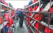  ?? WANG BIAO / FOR CHINA DAILY ?? Workers from a funeral parlor of Fuyang, Anhui province, walk through aisles of unclaimed urns this month.