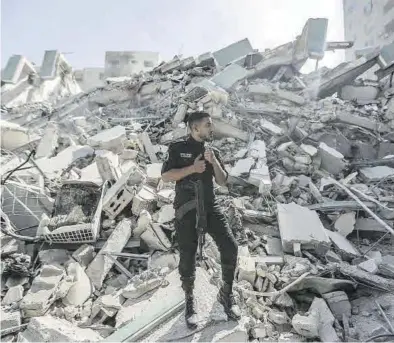  ?? EFE / MOHAMMED SABER ?? Un policía palestino, en los escombros de la torre Al-Jalaa, sede de varios medios de comunicaci­ón, en Gaza.