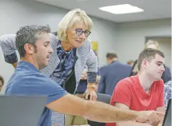  ?? NATI HARNIK/ASSOCIATED PRESS FILE PHOTO ?? U.S. Education Secretary Betsy DeVos talks to students in a coding class Sept. 13 in Omaha, Neb. On Friday, she scrapped Obama-era guidelines that had demanded colleges use the lowest standard of proof, ‘prepondera­nce of the evidence,’ in deciding...