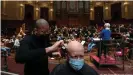  ?? ?? The resident orchestra, conducted by Susanna Malkki, played American composer Charles Ives' Symphony Number 2, while two hairdresse­rs cut hair in the historic venue
