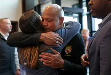  ?? Kevin Dietsch/Getty Images ?? Mr. Moore gets a hug during his visit to the SBA Business Recovery Center.