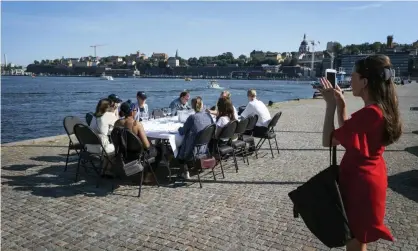  ?? Photograph: Stina Stjernkvis­t/AP ?? A socially distanced after-work drink in Stockholm. Sweden is considerin­g local lockdowns.