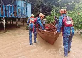  ?? (Foto ihsan APM) ?? Anggota APM membantu mangsa banjir di Kota Marudu, kelmarin.