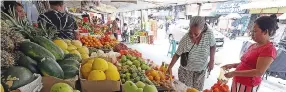  ?? ?? A VENDOR arranges fruits at a stall in San Andres, Malate, Dec. 27, 2023.
