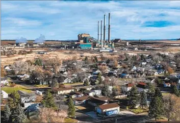  ?? THE SMOKESTACK­S Robert Gauthier Los Angeles Times ?? of the Colstrip coal power plant in Montana loom over the town.