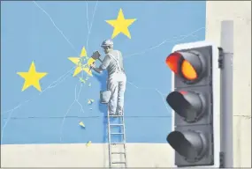  ??  ?? Un mural del artista británico Banksy muestra a un obrero quebrando una de las estrellas de la bandera de la Unión Europea.