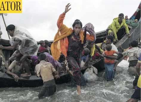  ?? DAN KITWOOD / GETTY IMAGES ?? Rohingya refugees jump from a wooden boat as it begins to tip over on Tuesday, after travelling from Myanmar, in Dakhinpara, Bangladesh.