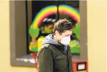  ?? Noah Berger / Special to The Chronicle ?? Nick Anderson wears a mask while waiting in line to shop at Trader Joe’s in Oakland. Grocery stores remain open.