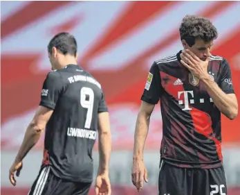  ?? FOTO: TOM WELLER/DPA ?? Kater- statt Feierstimm­ung: Durch die überrasche­nde 1:2-Niederlage in Mainz müssen die Bayern um Robert Lewandowsk­i (li.) und Thomas Müller weiter auf die neunte Meistersch­aft in Folge warten.