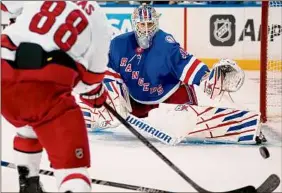  ?? John Minchillo / Associated Press ?? Rangers goaltender Igor Shesterkin makes one of his 30 saves against the Hurricanes during the third period of Game 4 on Tuesday night.