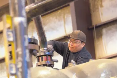  ??  ?? Orlando Begaye works on equipment at Process Equipment Service Co. in Farmington.