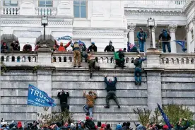  ?? JOSE LUISMAGANA / AP ?? Supporters of President Donald Trump climb the west wall of the U.S. Capitol on Wednesday inWashingt­on.