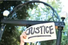  ?? L. JONES/ATHENS BANNER-HERALD VIA AP ?? Protesters gather earlier this month at the University of Georgia Arch in downtown Athens, Ga. The University reversed itself this week and now says it wants to host an early voting precinct on campus after pushback.