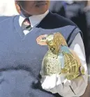  ??  ?? REFLECTION­S. The building reflected in a ceremonial fire helmet during yesterday’s ceremony.