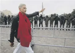  ??  ?? 0 Opposition leader Maria Kolesnikov­a passes riot police at the demo