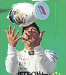  ?? FOTO: AFP ?? Noch’n Pokal: Für Lewis Hamilton läuft es bestens derzeit in der Formel 1. Karrieresi­eg Nr. 67 war einer der Marke „unverhofft“, der Hungarorin­g galt nicht als Mercedes-Strecke.