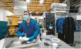  ?? ?? Test engineer Jacob Wilcox holds an ingot of sodium metal after cutting into it this month at TerraPower in Washington state. Nuclear energy technology is undergoing a reboot in the U.S.