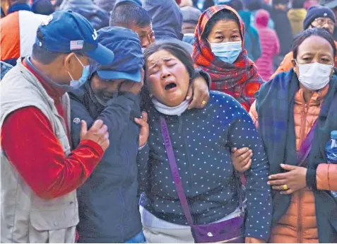  ?? ?? A woman cries as the body of a relative is brought to a hospital in Pokhara; the plane filmed just before the crash